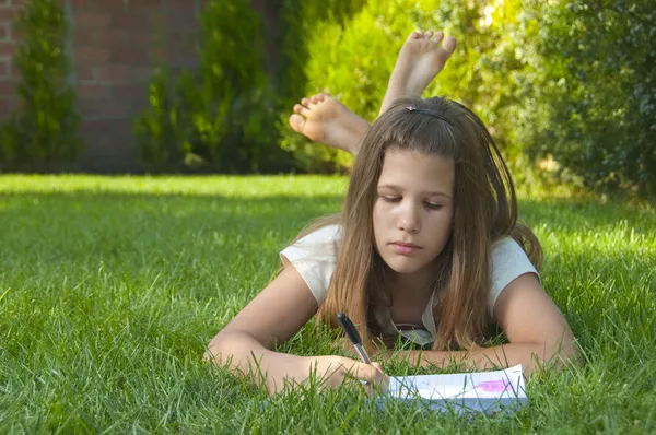 Mooie jonge tiener meisje op het gras — Stockfoto