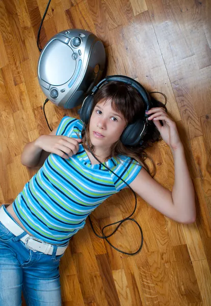 Adolescente jaz no chão e ouve a música — Fotografia de Stock