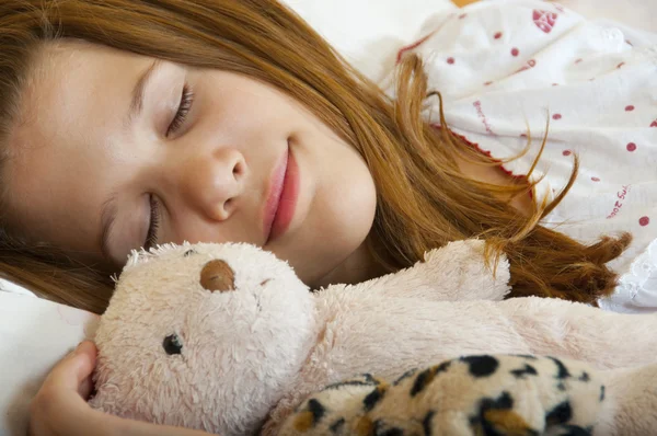 Mladá dospívající dívka spí mírumilovně s její oblíbené dětské hračky struktuře vedle tlačítka — Stock fotografie