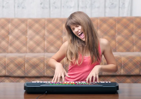 Teenage girl plays on synthesizer and sings. — Stock Photo, Image
