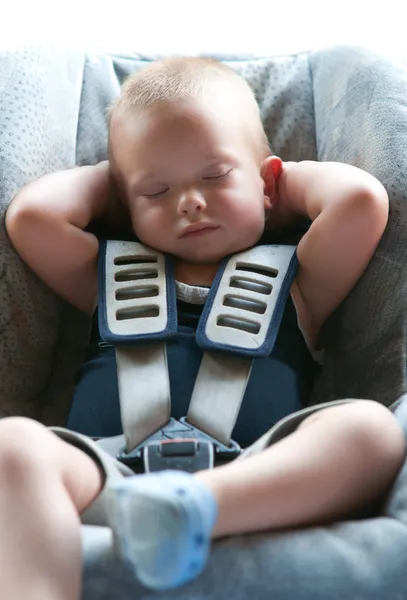 Niño pequeño duerme tranquilamente asegurado con cinturones de seguridad mientras está en el coche . —  Fotos de Stock