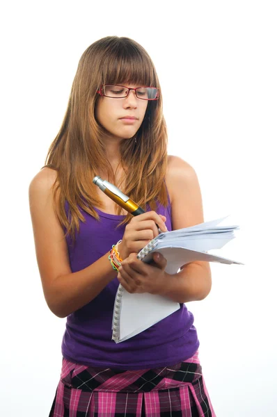 Jong meisje met glazen schrijft op het papier met behulp van gigantische potlood. — Stockfoto