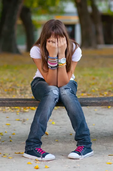 Молодая девушка сидит в парке — стоковое фото