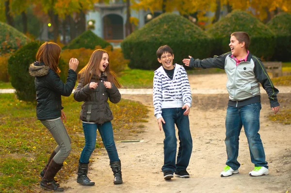 Teenage boys and girls having fun in the park on beautiful autumn day — Stock Photo, Image