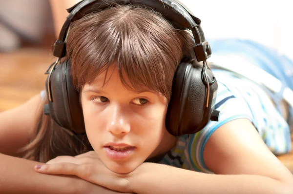 Vrij tienermeisje luisteren naar muziek, terwijl liggend op de vloer — Stockfoto