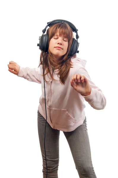 Beautiful teenage girl dances to the music with headphones on her head — Stock Photo, Image