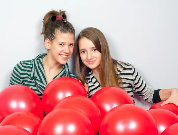 Красивые девочки-подростки играют с красными шариками — стоковое фото