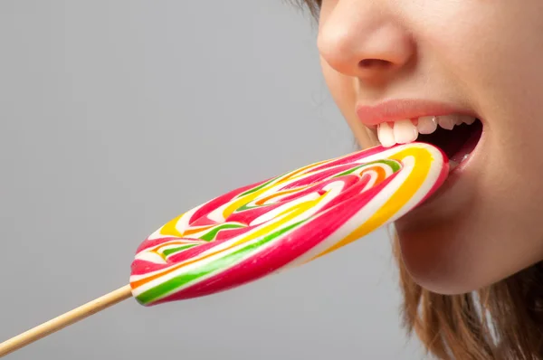 Detail of the beautiful girls face with huge lollipop between her teeth — Stock Photo, Image