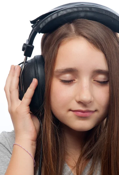 Menina adolescente bonita com olhos fechados escuta música através da cabeça — Fotografia de Stock