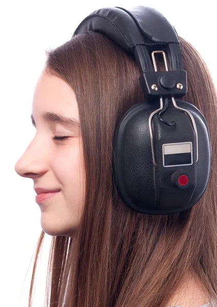 Beautiful teenage girl with closed eyes listens to music through the headph — Stock Photo, Image