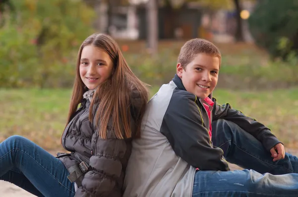 Мальчик-подросток и девочка наслаждаются друг с другом компанией в парке на красивой — стоковое фото