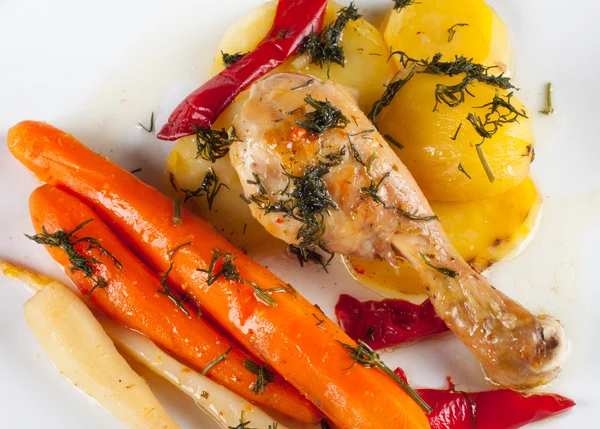 stock image Delicious dish consisting of crispy roasted chicken leg, potatoes, carrots,