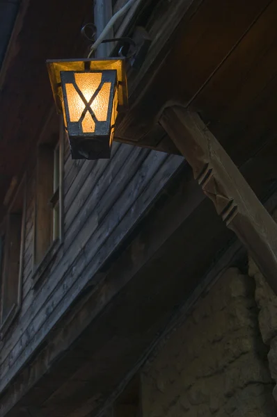 Старый фонарь висит перед старым деревянным домом — стоковое фото