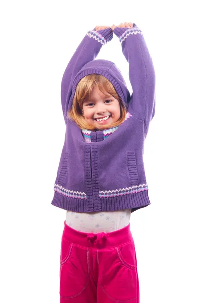 Niña bonita sonríe y sostiene sus manos en alto en el aire — Foto de Stock