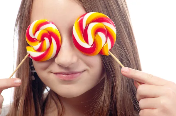 Beautiful teenage girl hiding her eyes with lollipops — Stock Photo, Image