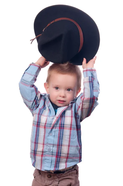 Menino bonito sorri enquanto segurava chapéu de cowboy atrás das costas — Fotografia de Stock