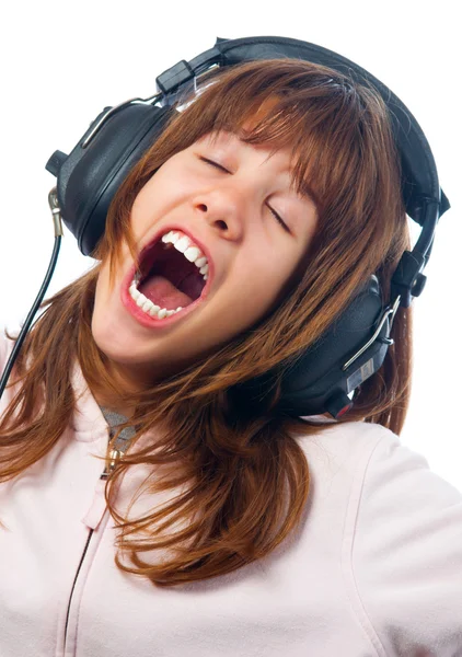 Beautiful teenage girls sings while listening music through headphones — Stock Photo, Image