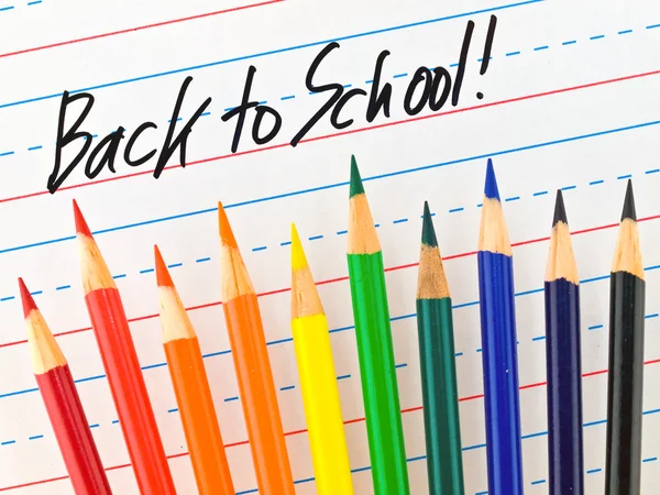 Voltar para a escola Escrito em uma placa de borramento seco forrado com lápis coloridos — Fotografia de Stock