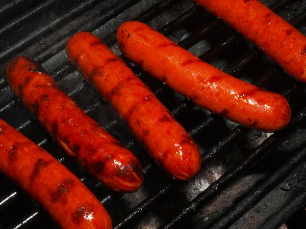 Eine Reihe von fünf Hotdogs auf einem Grill — Stockfoto