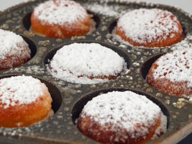 A Pan of Freshly Cooked Aebelskivers with Powdered Sugar clipart