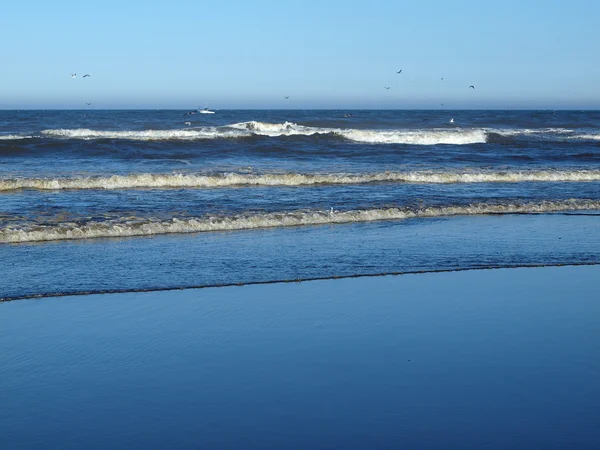 Océano olas rompiendo en la orilla en un día claro y soleado — Foto de Stock