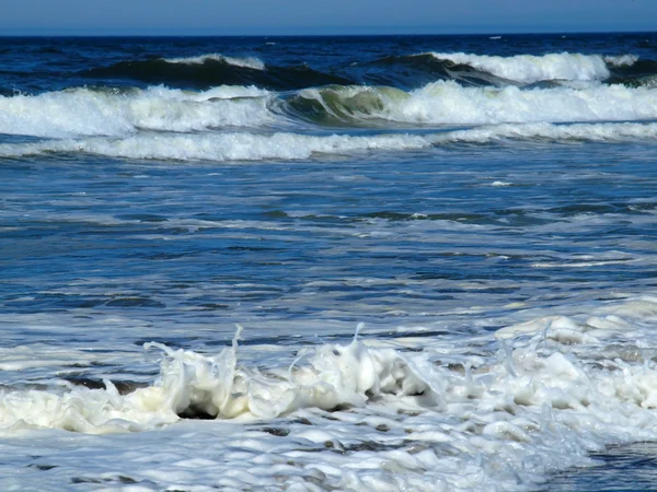 Oceánu vlnu, tříštící se o pobřeží slunečného dne — Stock fotografie