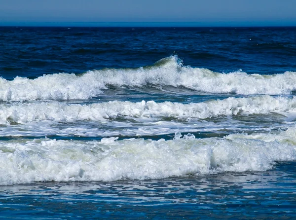 En ocean våg bryter på stranden en solig dag — Stockfoto