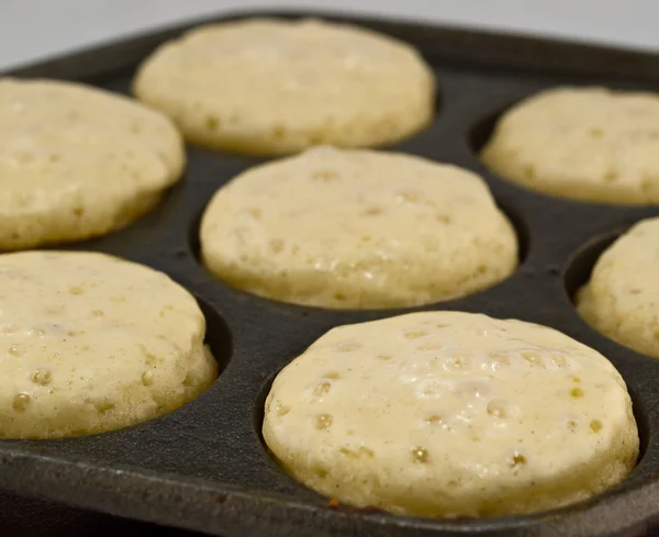 A Batch of Aebelskivers Cooking in a Pan