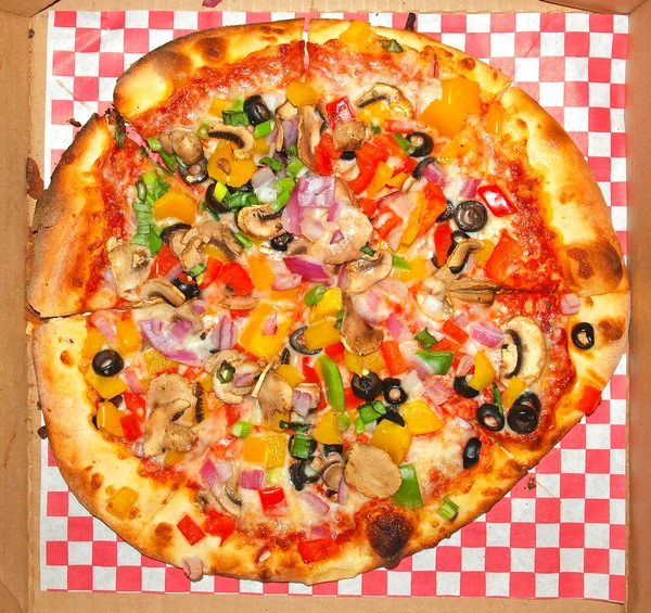 赤チェック紙に新鮮でヘルシーな野菜のピザ — ストック写真