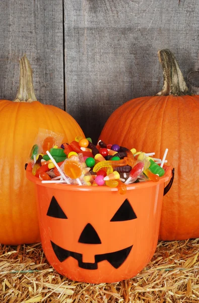 Cubo de calabaza de halloween relleno de caramelo —  Fotos de Stock