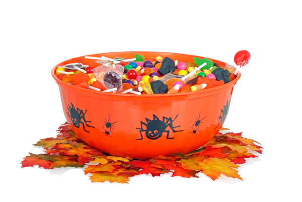 Halloween candy in a bowl with fall leaves