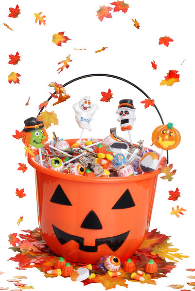 Halloween pumpkin bucket with candy and falling leaves