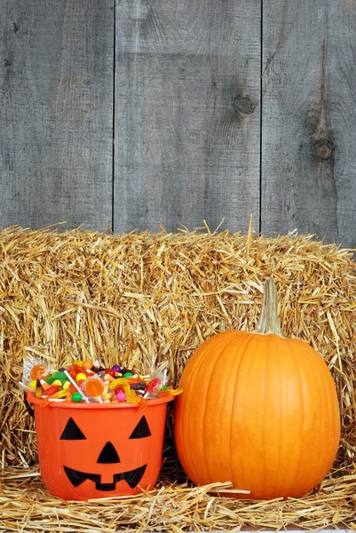 Doces de Halloween e abóbora no celeiro — Fotografia de Stock
