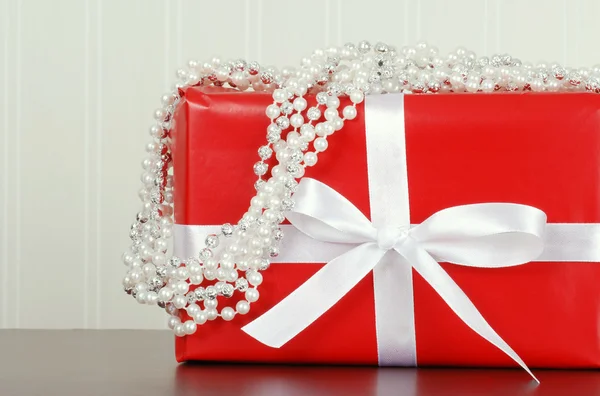 Röd julklapp med pärla garland — Stockfoto