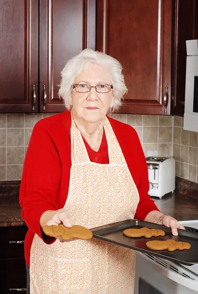 Femme âgée avec pain d'épice bonhomme de neige — Photo