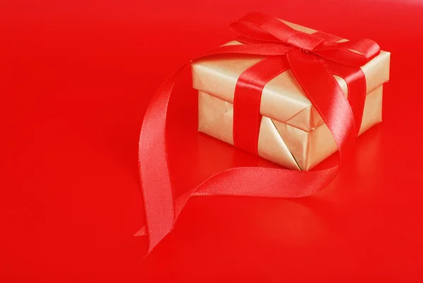 Gold-Weihnachtsgeschenk auf Rot — Stockfoto
