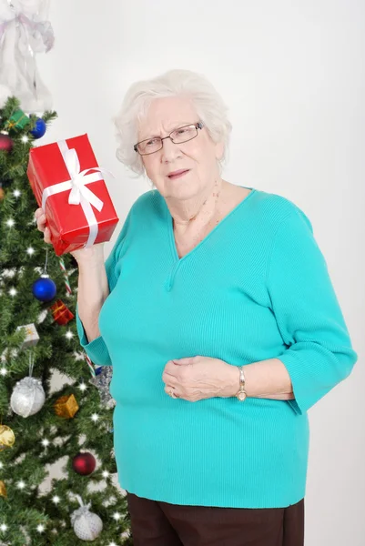 Senior woman guessing her christmas gift — Stok fotoğraf