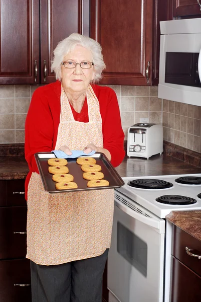新鲜烤饼干的高级女人 — 图库照片