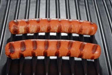 Two hotdogs on a grill clipart