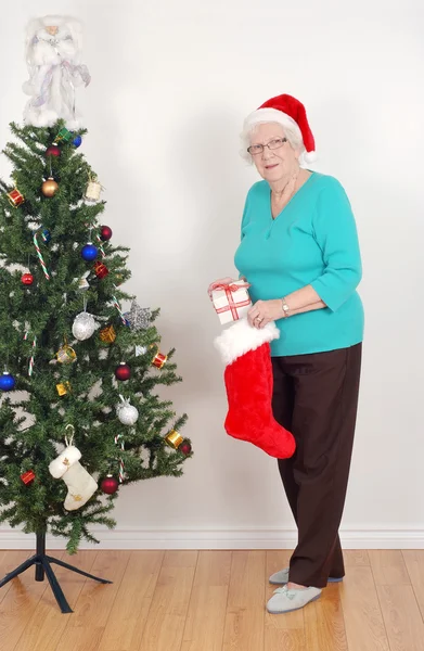Äldre kvinna med Tomtemössa och strumpa — Stockfoto