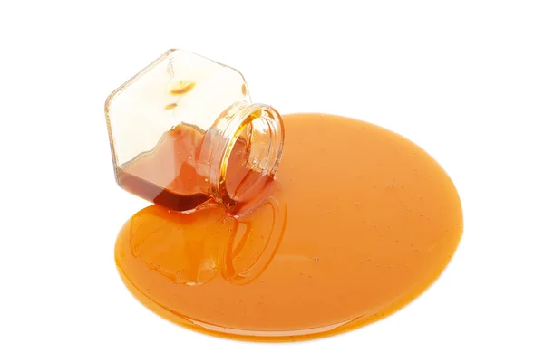 Derrame de miel de un frasco de vidrio — Foto de Stock