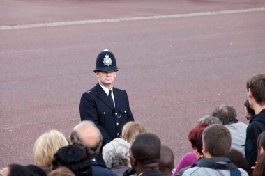 British policeman observes crowd clipart