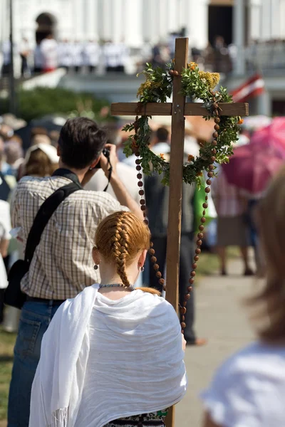 Молодая девушка стоя с крестом — стоковое фото