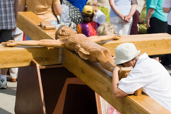 Donna di preghiera al grande crocifisso in legno — Foto Stock