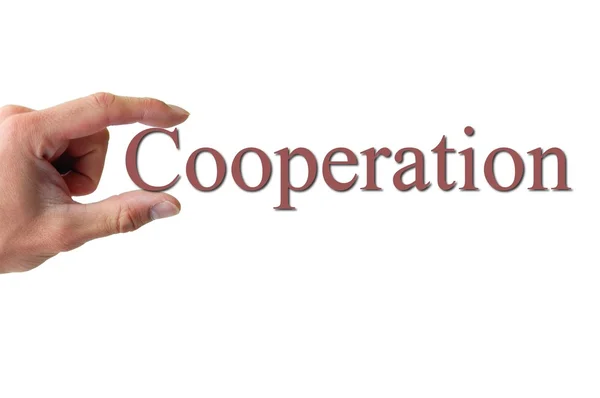 Mano sosteniendo la palabra cooperación — Foto de Stock
