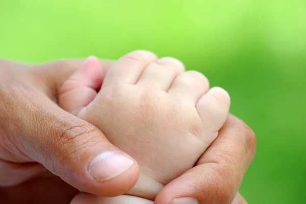 Ruka dítěte je v otcovské ruce — Stock fotografie