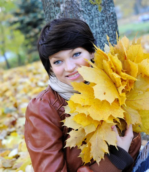 Girl in autumn with maple leaves — Stock Photo, Image
