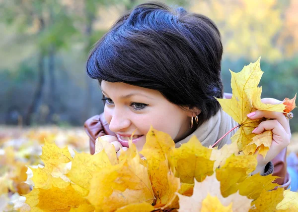 Chica en otoño con hojas de arce — Foto de Stock