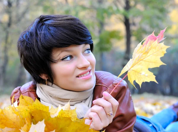 Girl in het najaar met esdoorn bladeren — Stockfoto