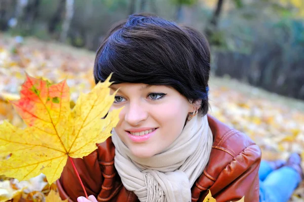Girl in het najaar met esdoorn bladeren — Stockfoto